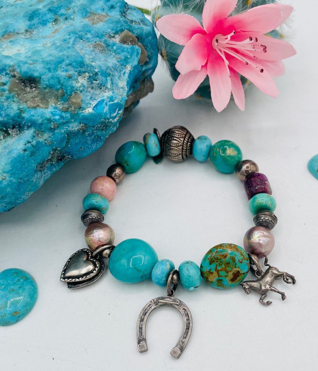 Beaded stretch bracelet featuring Kingman turquoise, royal beauty turquoise, pearls, rhodochrosite, purple turquoise, sterling silver beads and vintage sterling silver charms. Available only from Rockstar Cowgirl online or in store in Cody, Wyoming.
