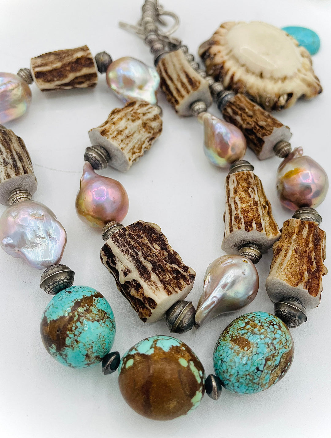 Handmade beaded necklace featuring textured deer antler beads, #8 turquoise nuggets, natural luster flameball pearls, and sterling silver beads. Available only from Rockstar Cowgirl online or in store in Cody, Wyoming. 