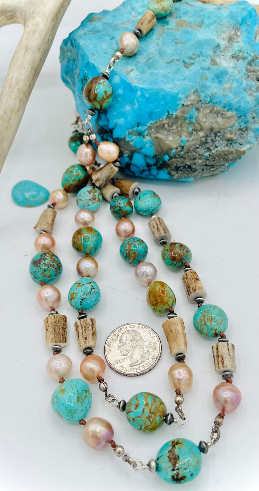 Silk knotted and wire wrapped treasure necklace with two nested strands featuring Kingman turquoise nuggets, deer antler beads, Edison natural luster pearls, and sterling silver beads. U.S. quarter for size reference. Available only from Rockstar Cowgirl online or in store in Cody, Wyoming.