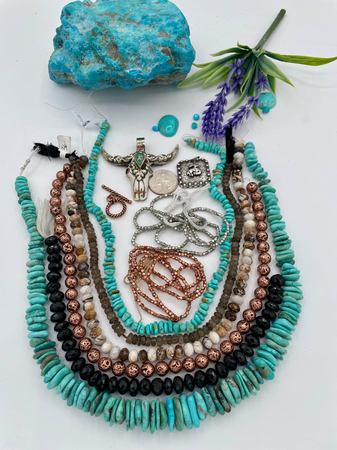 Bead box featuring Campitios and Sonoran turquoise, Australian chrysoprase, spinel, smokey quartz, copper plated lava, with a bone steer pendent. U.S. quarter for size reference. Available only from Rockstar Cowgirl online or in store in Cody, Wyoming.