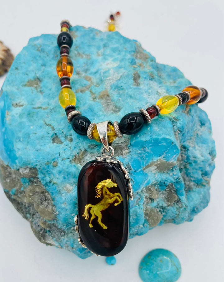 Beaded Baltic amber and sterling silver necklace featuring a Baltic amber and sterling silver pendent with a carved horse reverse cameo. Available only from Rockstar Cowgirl online or in store in Cody, Wyoming.