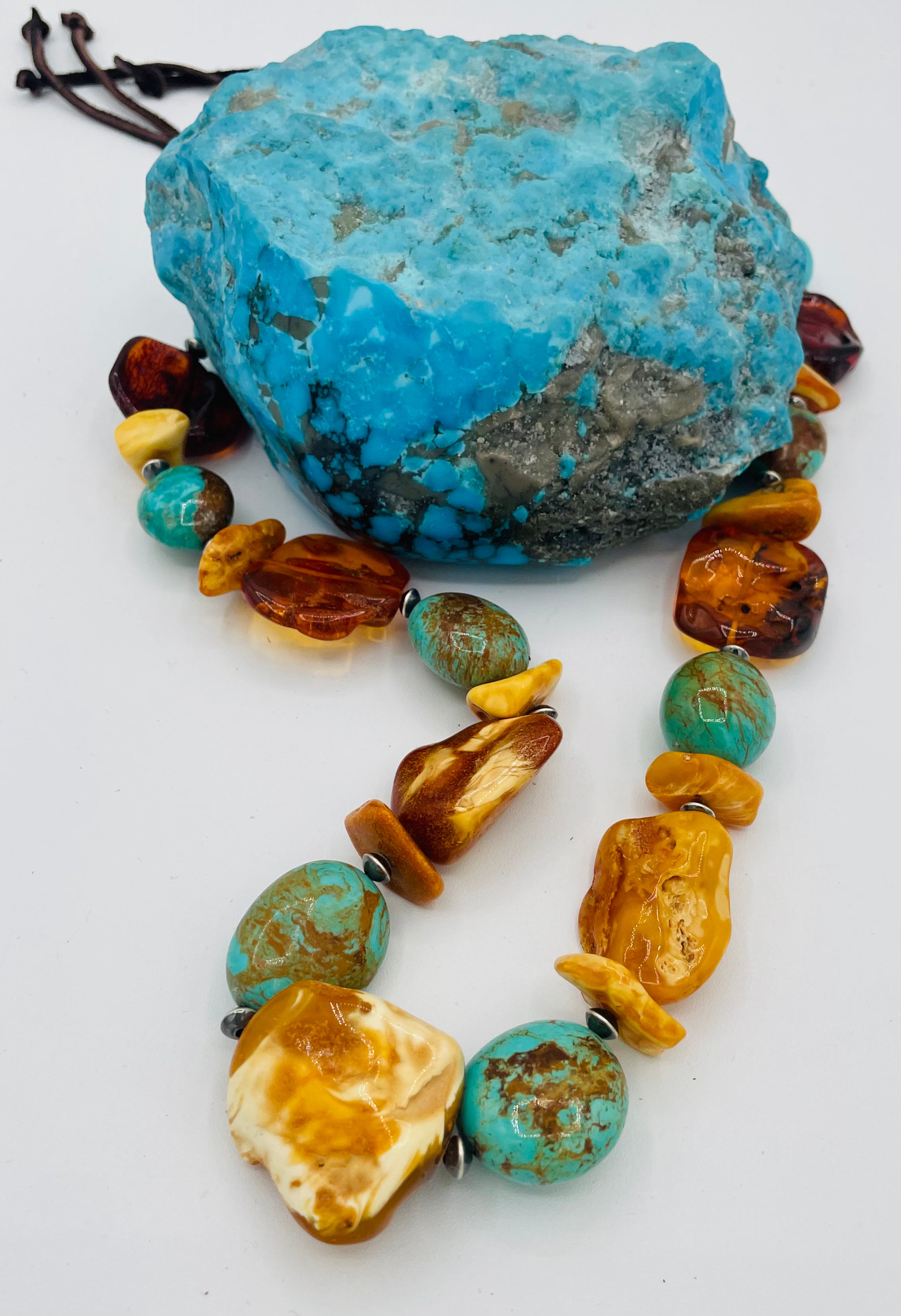Adjustable beaded hatband featuring Kingman turquoise, Baltic amber, and sterling silver Navajo pearl beads and finished with deer leather and a silicone slide bead. Available only from Rockstar Cowgirl online or in store in Cody, Wyoming.