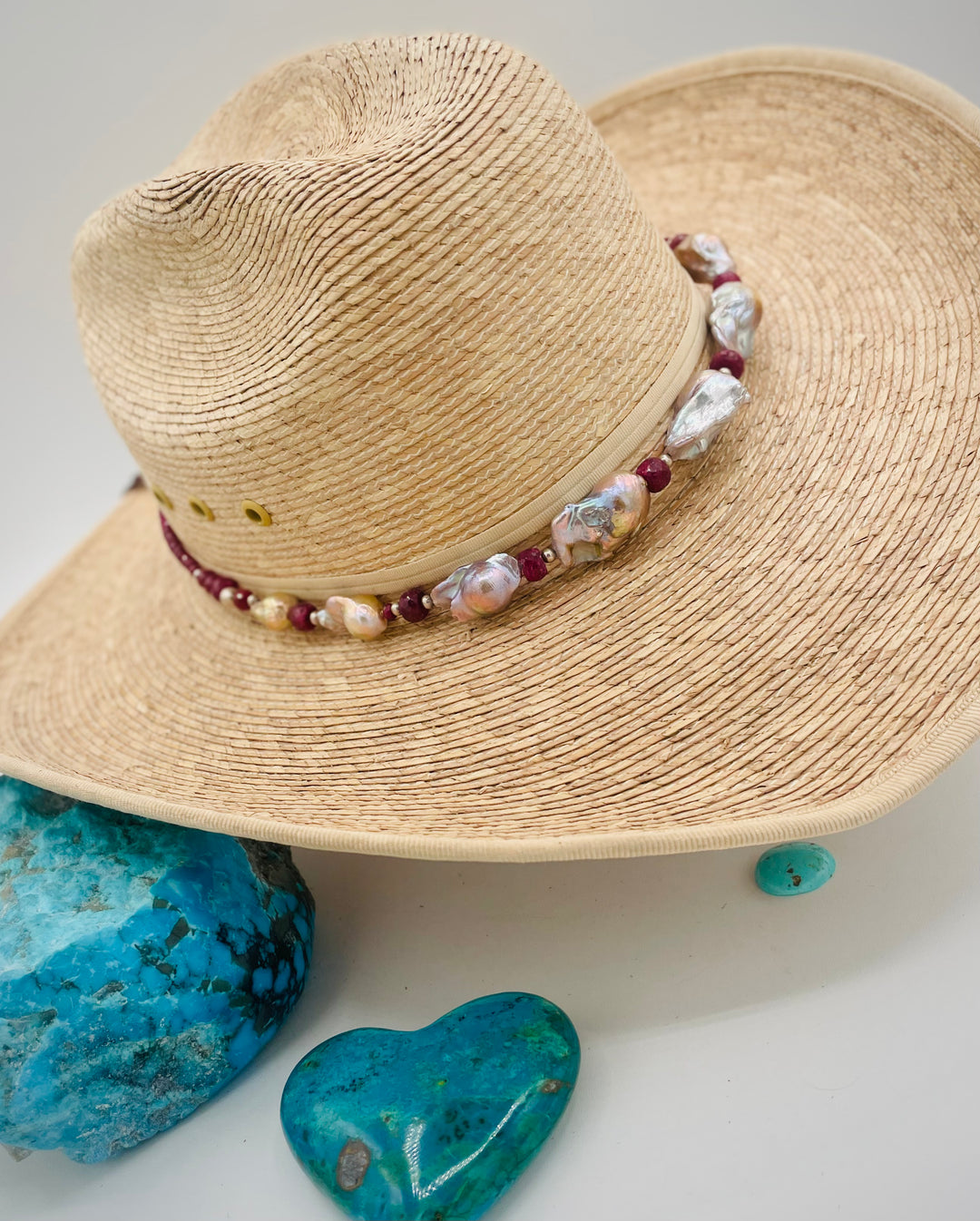 Adjustable beaded hatband featuring flameball natural luster baroque pearls, ruby, sterling silver beads, African silver, and finished with deer lace in the back. Available only from Rockstar Cowgirl online or in store in Cody, Wyoming.