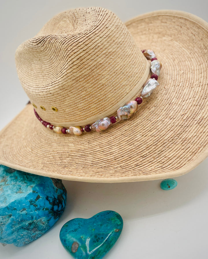 Adjustable beaded hatband featuring flameball natural luster baroque pearls, ruby, sterling silver beads, African silver, and finished with deer lace in the back. Available only from Rockstar Cowgirl online or in store in Cody, Wyoming.