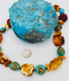 Adjustable beaded hatband featuring Kingman turquoise, Baltic amber, and sterling silver Navajo pearl beads and finished with deer leather and a silicone slide bead. U.S. quarter for size reference. Available only from Rockstar Cowgirl online or in store in Cody, Wyoming.