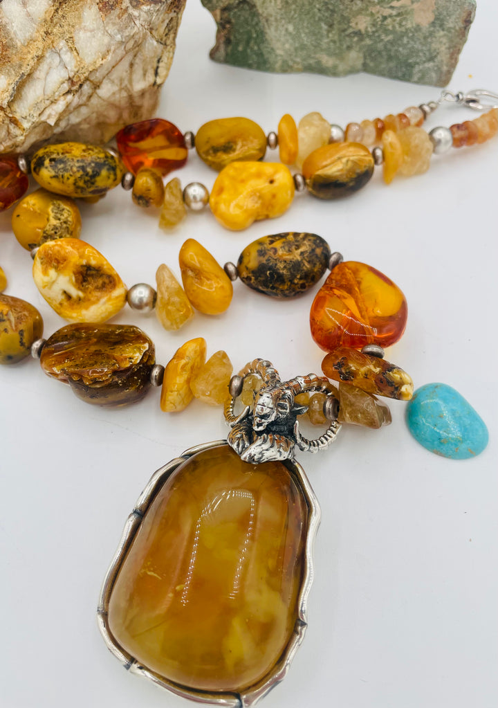 Beaded necklace featuring Baltic amber nuggets and chips, citrine nuggets, sterling silver beads, with a sterling silver and Baltic amber mountain goat pendent. Available only from Rockstar Cowgirl online or in store in Cody, Wyoming. 