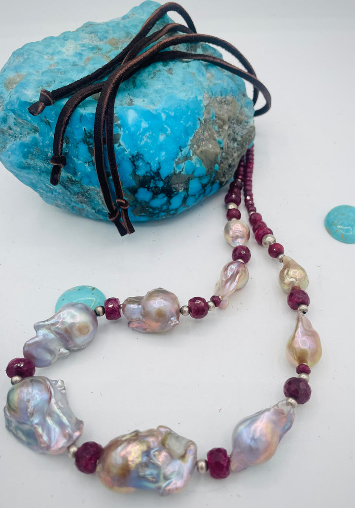 Adjustable beaded hatband featuring flameball natural luster baroque pearls, ruby, sterling silver beads, African silver, and finished with deer lace in the back. Available only from Rockstar Cowgirl online or in store in Cody, Wyoming.