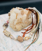 Baroque natural luster pearls, Edison pearls, knobby deer antler beads, moonstone, and sterling silver hatband finished with feathers, deer lace and slide bead. Available only from Rockstar Cowgirl online or in store in Cody, Wyoming.