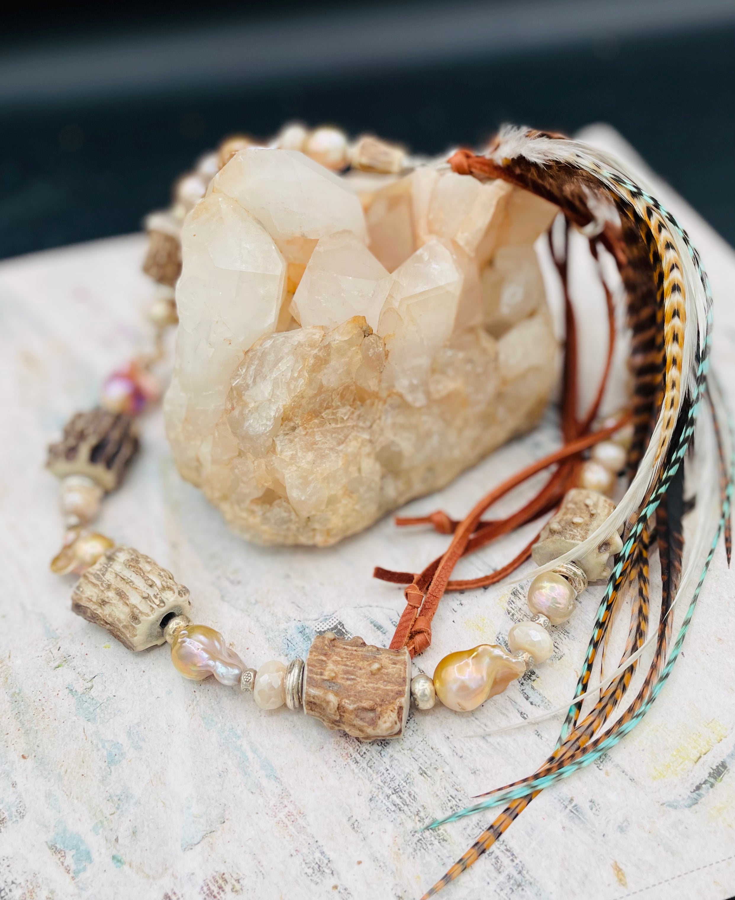 Baroque natural luster pearls, Edison pearls, knobby deer antler beads, moonstone, and sterling silver hatband finished with feathers, deer lace and slide bead. Available only from Rockstar Cowgirl online or in store in Cody, Wyoming.