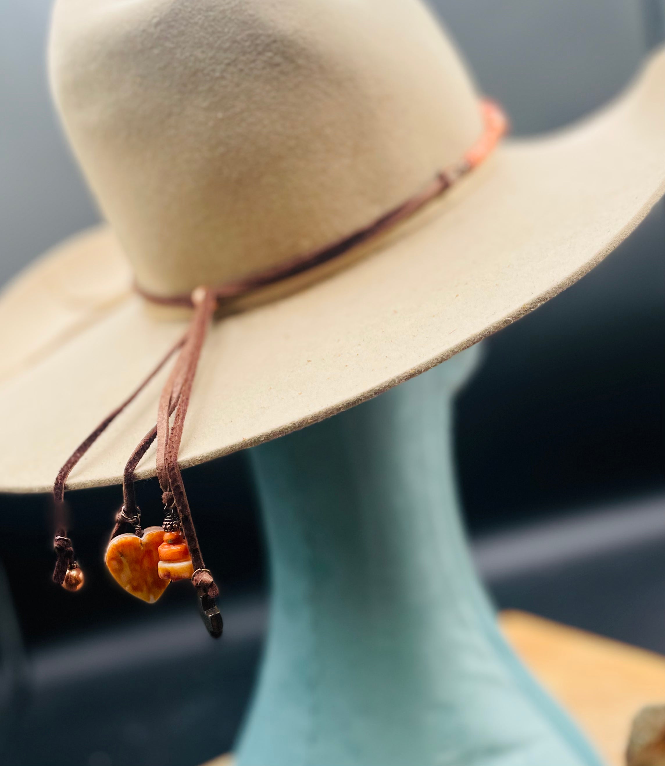 Close up of the charms hanging from the deer lace at the back of this spiny oyster and copper hatband or necklace. Available only from Rockstar Cowgirl online or in store in Cody, Wyoming.