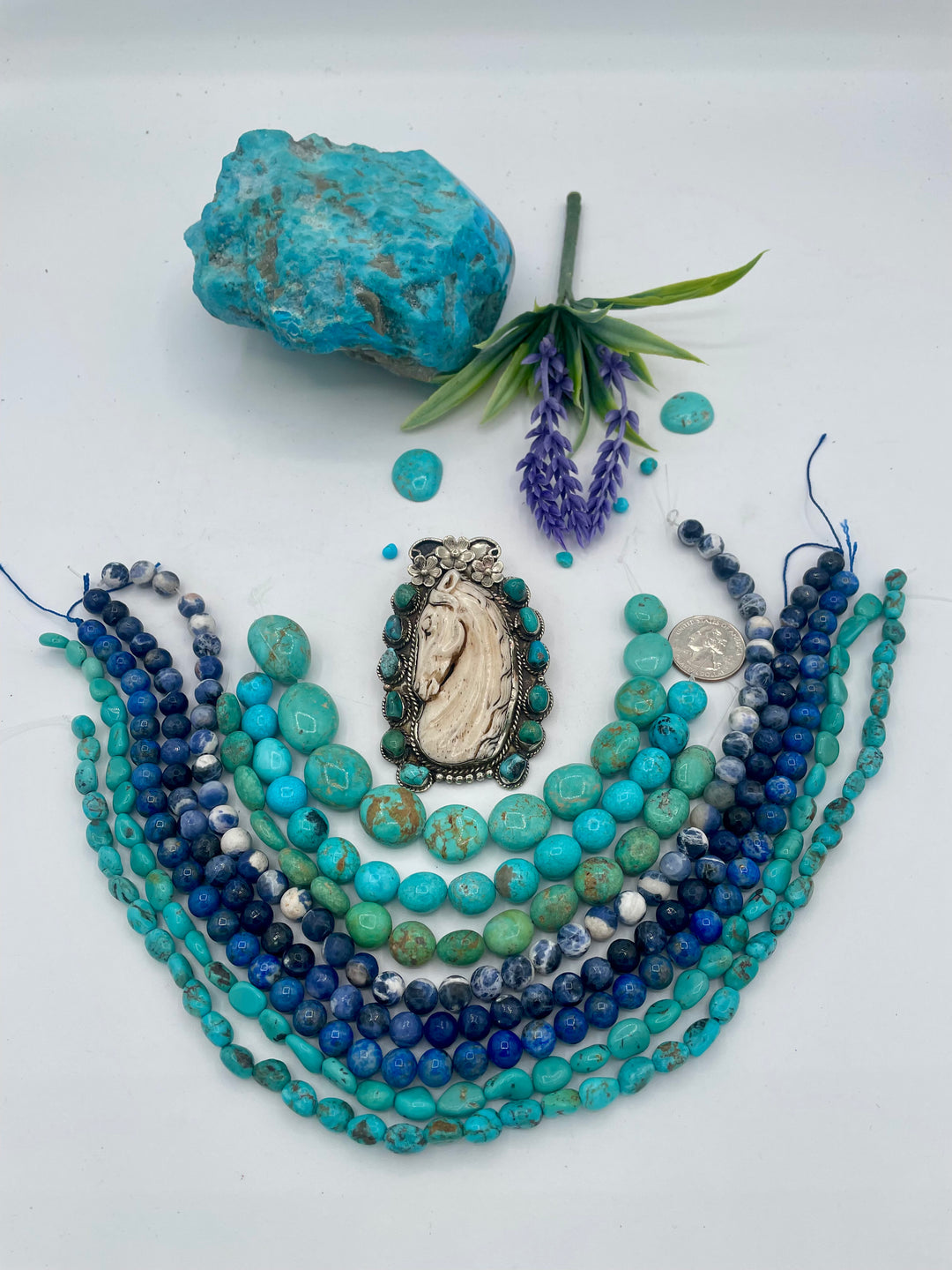 Bead box featuring Kingman turquoise nuggets in 3 colors, sodalite calcite, sodalite, denim lapis, Hubei turquoise, and carved bone horse and turquoise pendent. U.S. quarter for size reference. Available only from Rockstar Cowgirl online or in store in Cody, Wyoming.