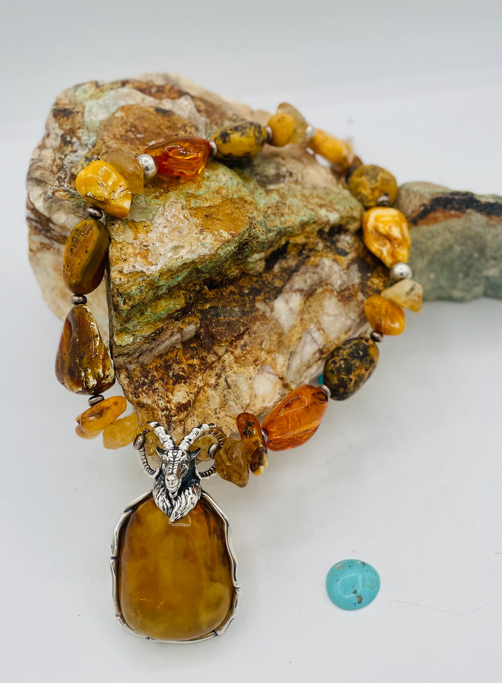 Beaded necklace featuring Baltic amber nuggets and chips, citrine nuggets, sterling silver beads, with a sterling silver and Baltic amber mountain goat pendent. Available only from Rockstar Cowgirl online or in store in Cody, Wyoming. 