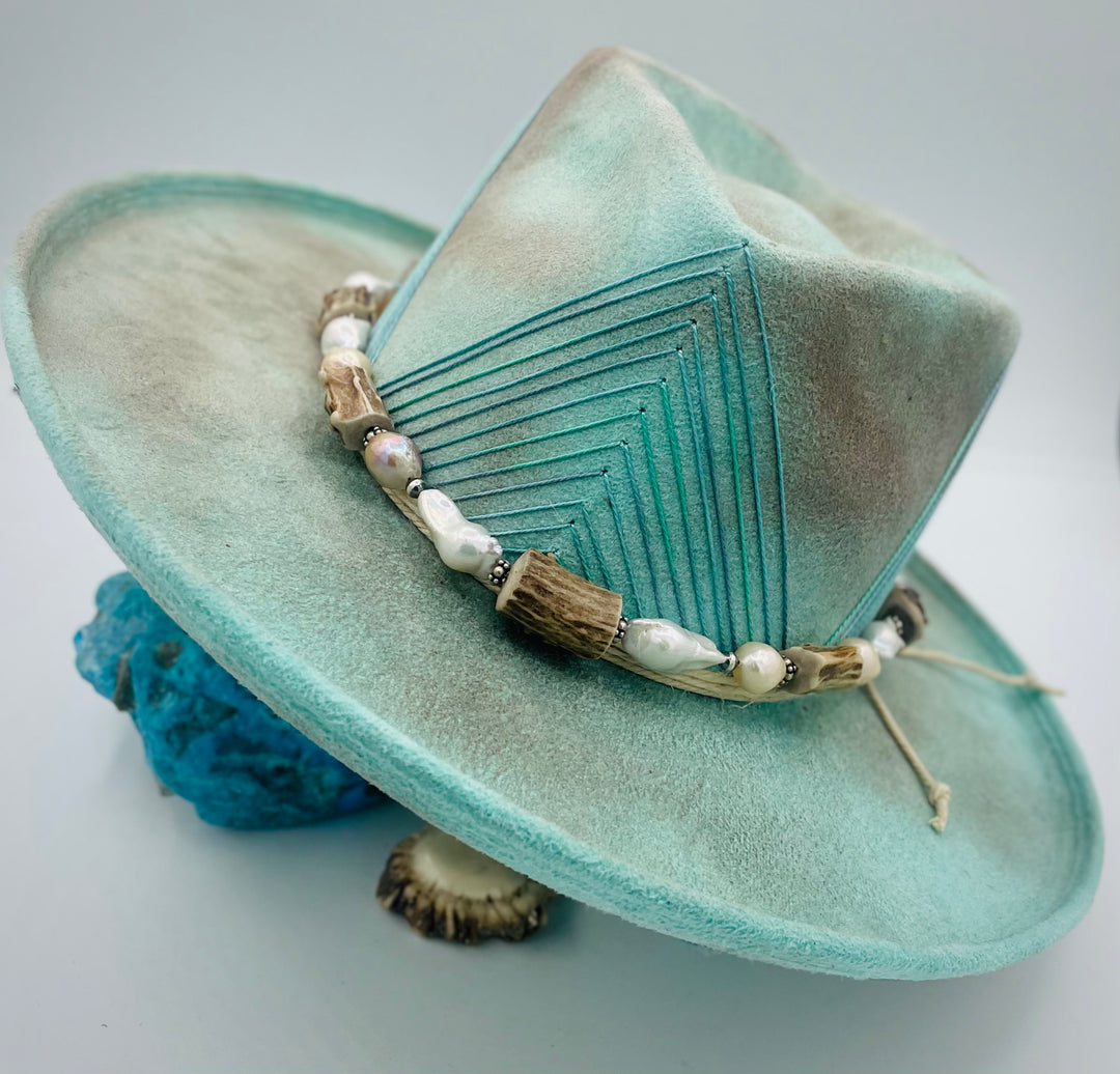 Adjustable beaded hattband featuring white flameball baroque pearls, textured deer antler, sterling silver beads, and finished with deer lace in the back. Available only from Rockstar Cowgirl online or in store in Cody, Wyoming.
