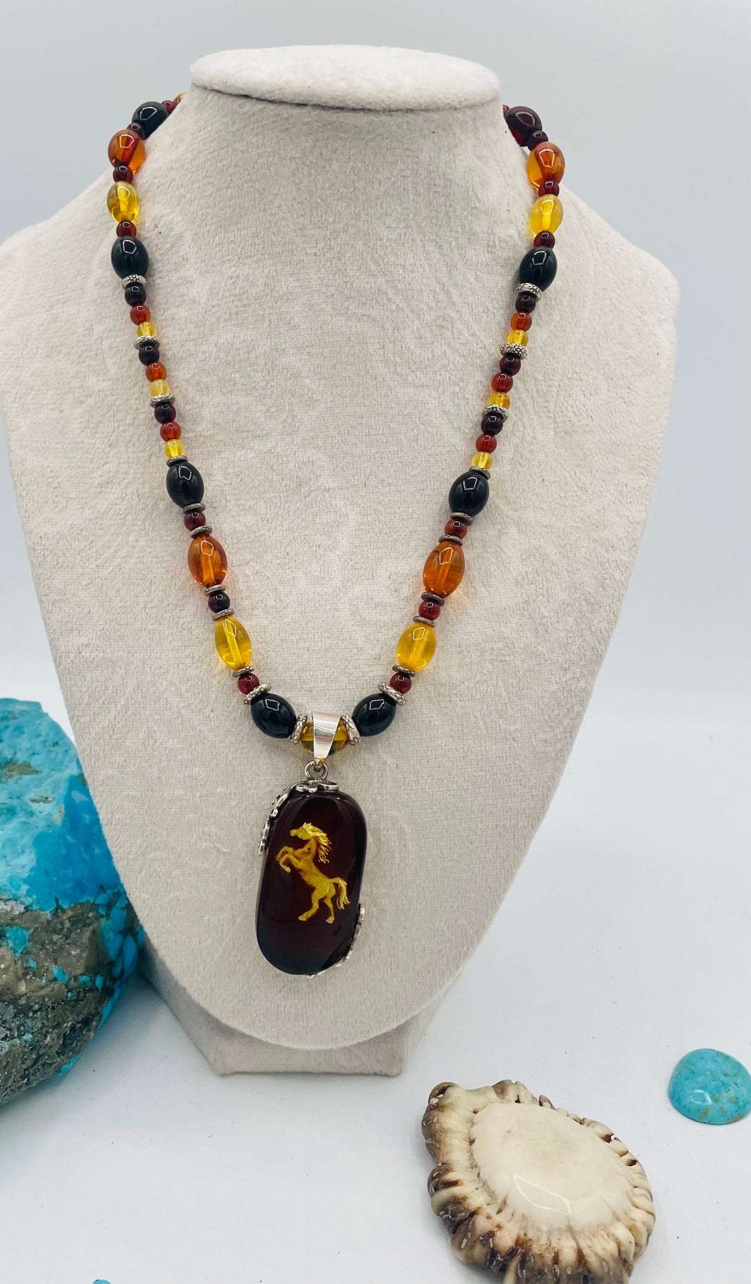 Beaded Baltic amber and sterling silver necklace featuring a Baltic amber and sterling silver pendent with a carved horse reverse cameo. Available only from Rockstar Cowgirl online or in store in Cody, Wyoming.