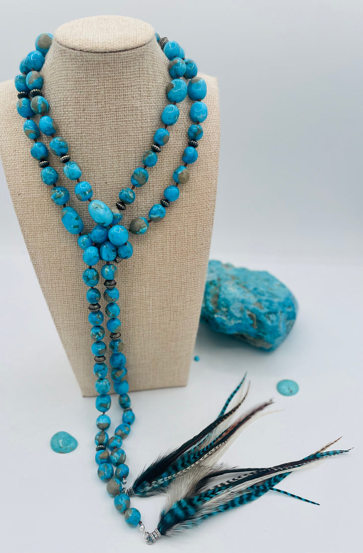 Silk knotted lariat featuring Ithaca peak turquoise, sterling silver beads, and feather tassels. Available only from Rockstar Cowgirl online or in store in Cody, Wyoming.