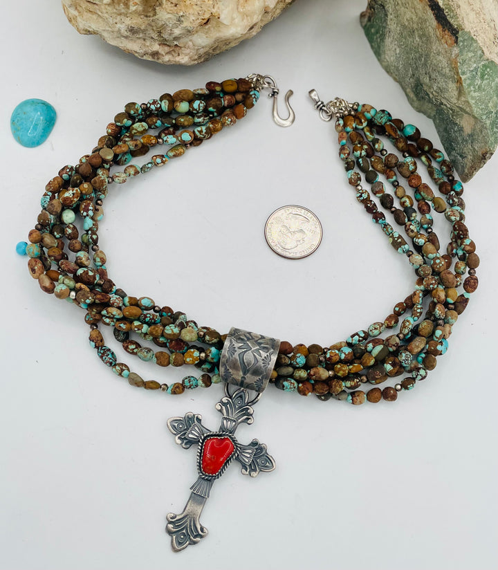 Beaded 7 strand necklace featuring #8 turquoise nuggets, sterling silver beads, with a coral and sterling silver cross pendent. U.S. quarter for size reference. Available only from Rockstar Cowgirl online or in store in Cody, Wyoming.
