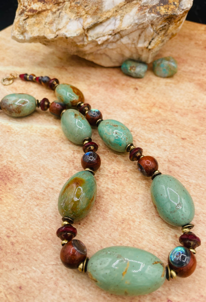 A close up showcasing the matrix in the green Kingman turquoise nuggets and the abalone inlaid wooden beads. Available only from Rockstar Cowgirl online or in store in Cody, Wyoming.