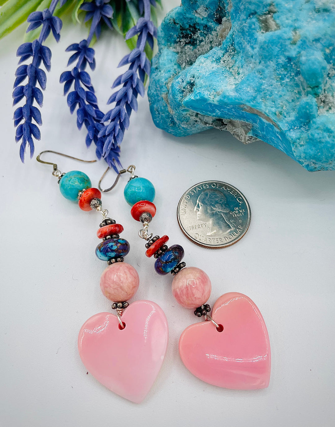 Handmade earrings featuring pink conch shell hearts, rhodochrosite, purple Mojave/ Mohave Kingman turquoise, and spiny oyster beads. U.S. quarter for size reference. Available only from Rockstar Cowgirl online or in store in Cody, Wyoming.