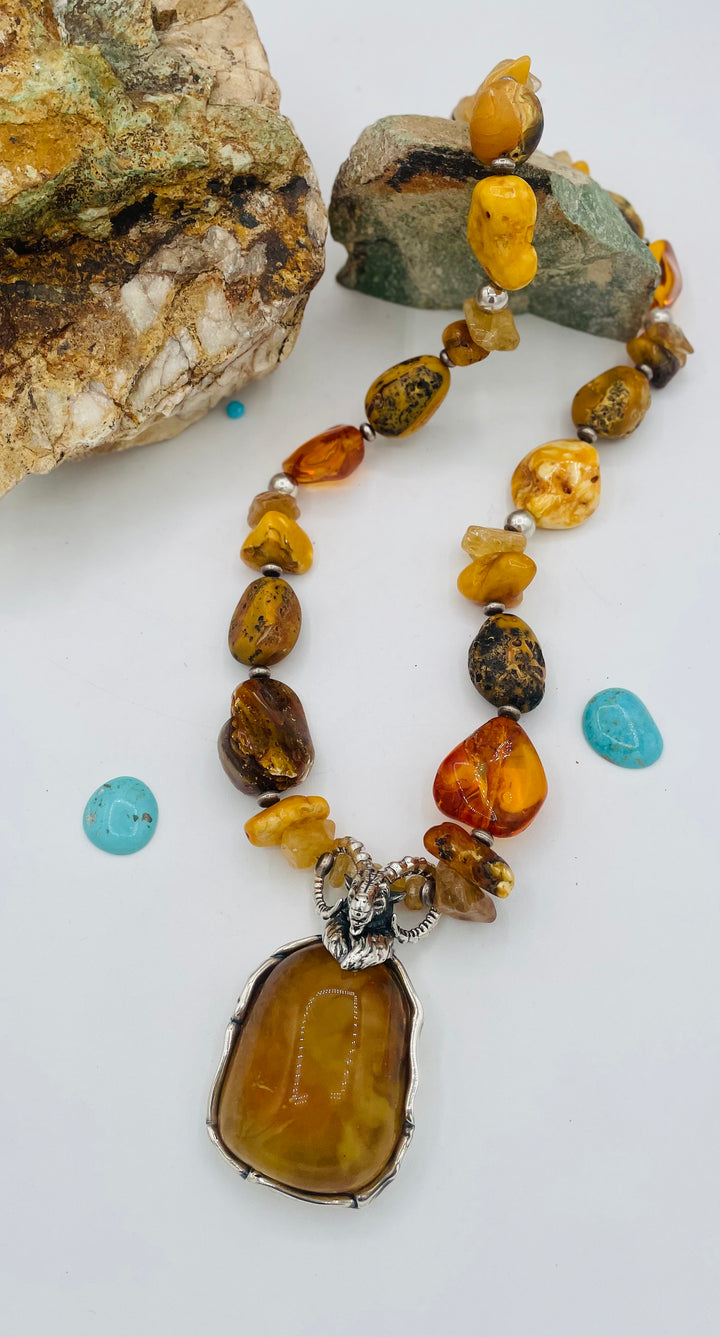 Beaded necklace featuring Baltic amber nuggets and chips, citrine nuggets, sterling silver beads, with a sterling silver and Baltic amber mountain goat pendent. Available only from Rockstar Cowgirl online or in store in Cody, Wyoming. 