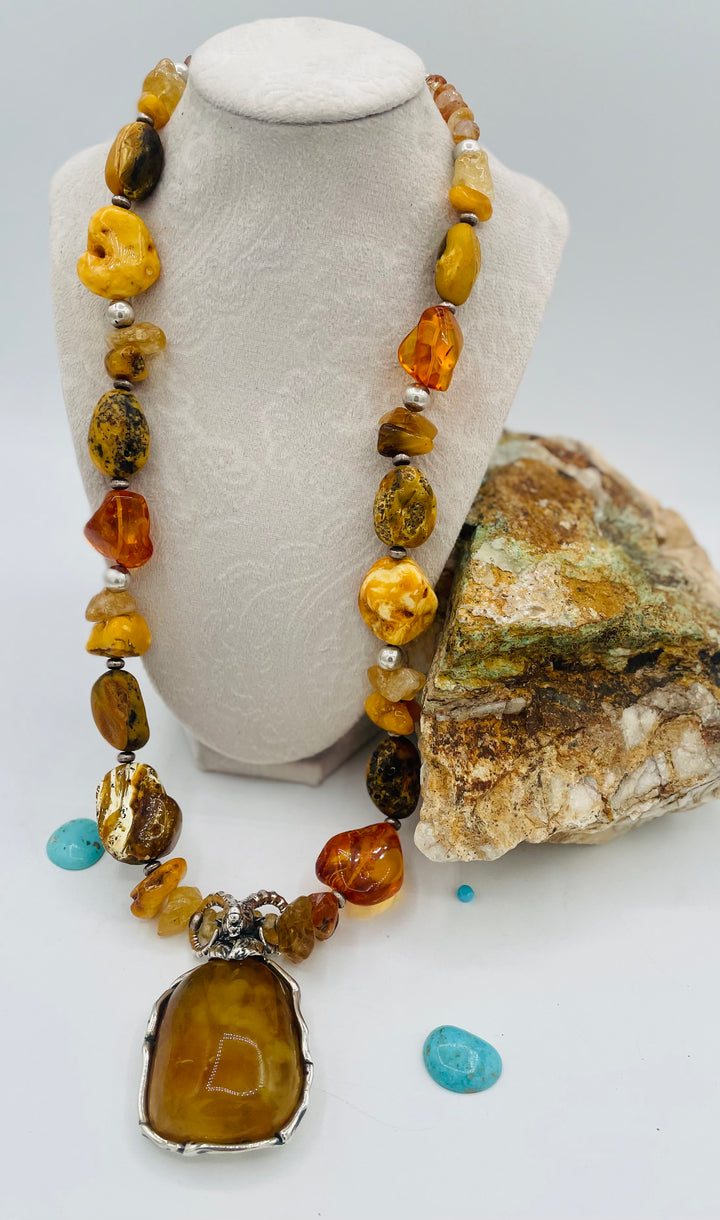Beaded necklace featuring Baltic amber nuggets and chips, citrine nuggets, sterling silver beads, with a sterling silver and Baltic amber mountain goat pendent. Available only from Rockstar Cowgirl online or in store in Cody, Wyoming. 