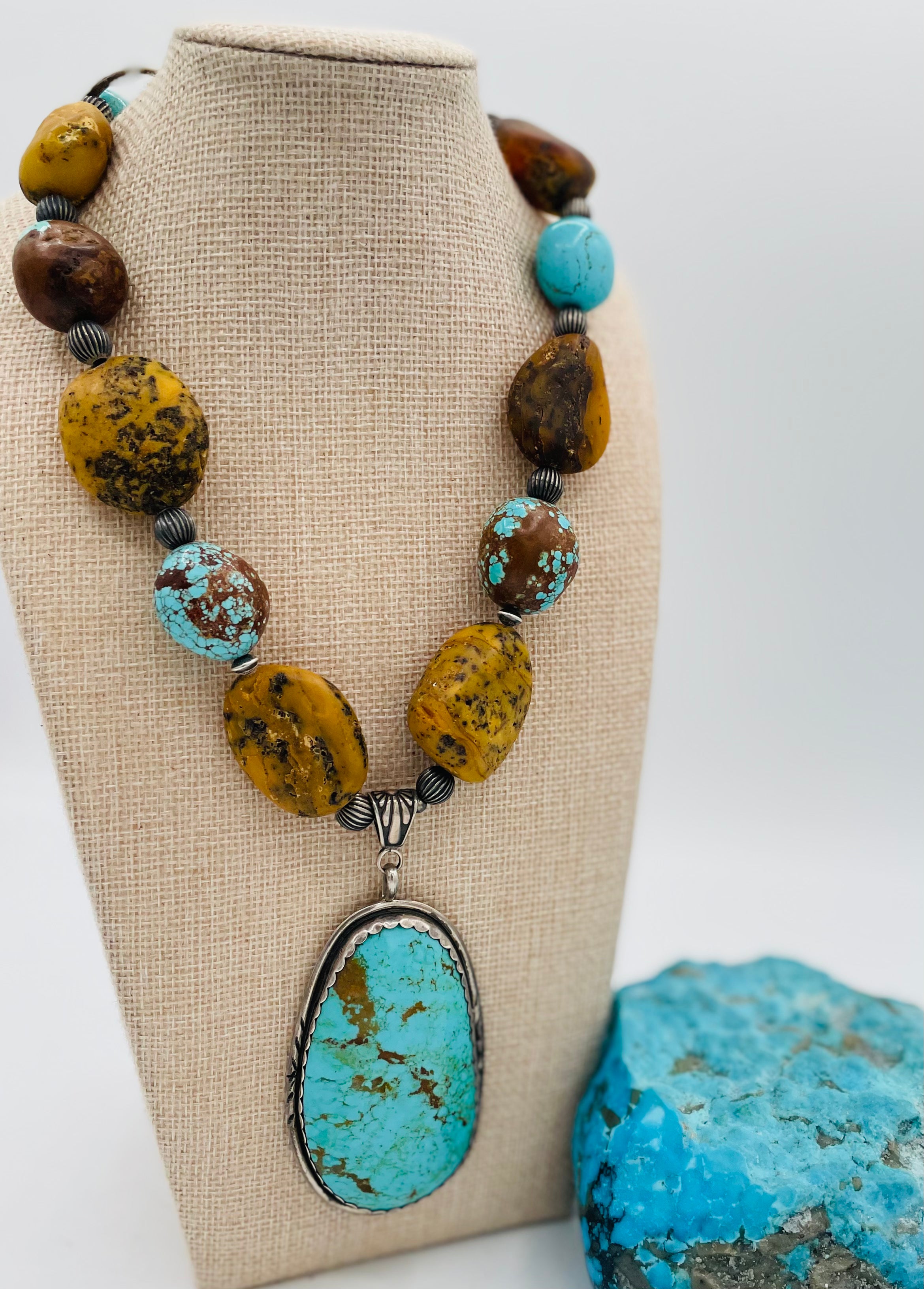Necklace featuring Kingman turquoise, #8 turquoise, yellow and black Baltic Amber, and sterling silver beads with a Kingman turquoise and sterling silver pendent. Available only from Rockstar Cowgirl online or in store in Cody, Wyoming.