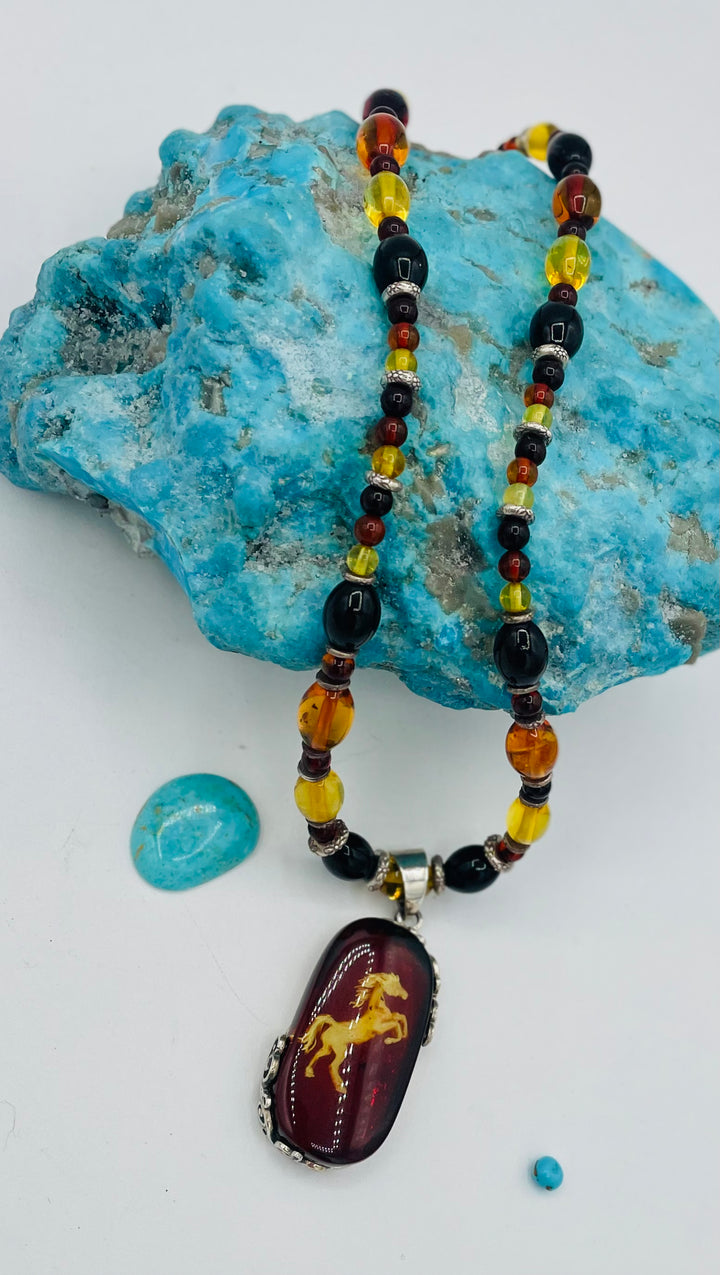 Beaded Baltic amber and sterling silver necklace featuring a Baltic amber and sterling silver pendent with a carved horse reverse cameo. Available only from Rockstar Cowgirl online or in store in Cody, Wyoming.