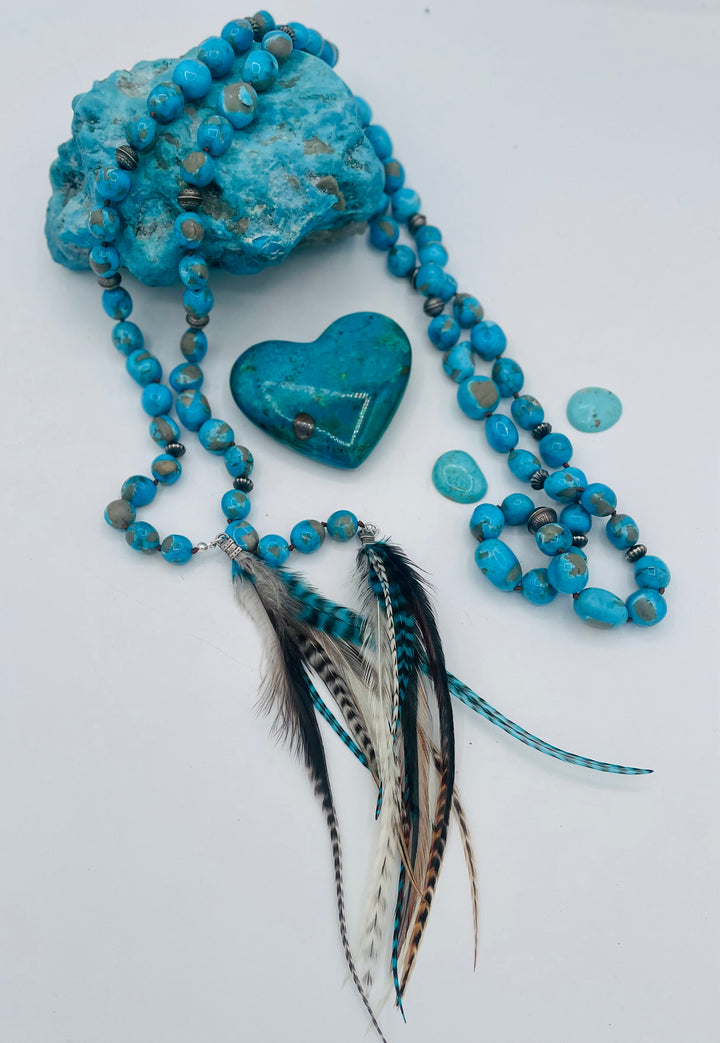 Silk knotted lariat featuring Ithaca peak turquoise, sterling silver beads, and feather tassels. Available only from Rockstar Cowgirl online or in store in Cody, Wyoming.