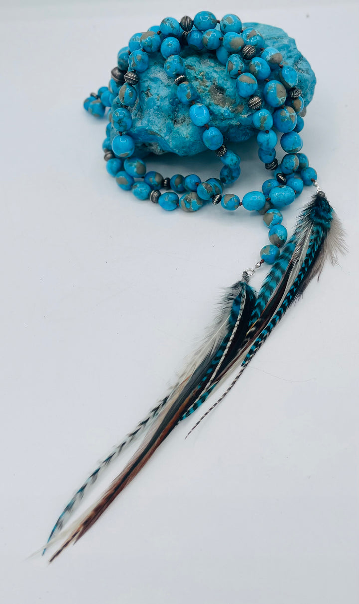 Silk knotted lariat featuring Ithaca peak turquoise, sterling silver beads, and feather tassels. Available only from Rockstar Cowgirl online or in store in Cody, Wyoming.