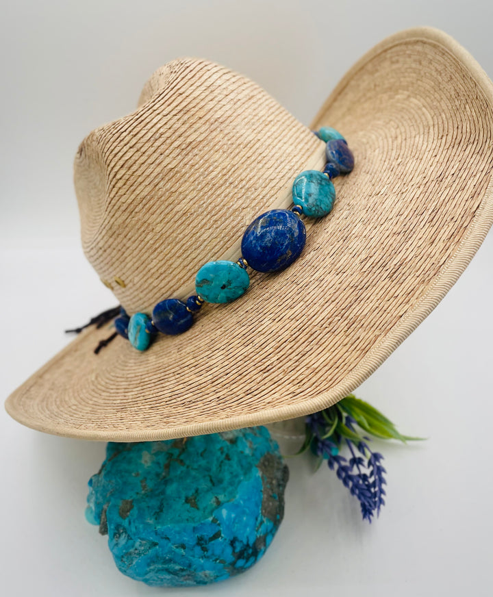 Adjustable beaded hatband featuring lapis nuggets, Kingman turquoise nuggets, African brass details, and finished with deer lace in the back. Available only from Rockstar Cowgirl online or in store in Cody, Wyoming.