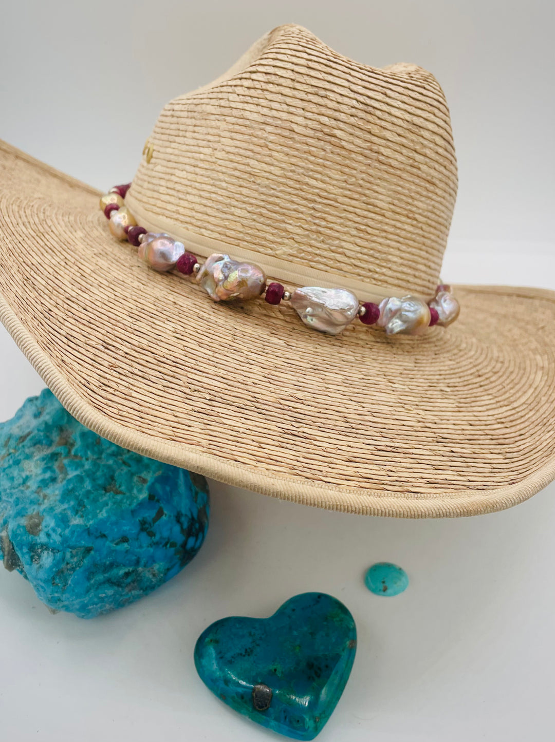 Adjustable beaded hatband featuring flameball natural luster baroque pearls, ruby, sterling silver beads, African silver, and finished with deer lace in the back. Available only from Rockstar Cowgirl online or in store in Cody, Wyoming.