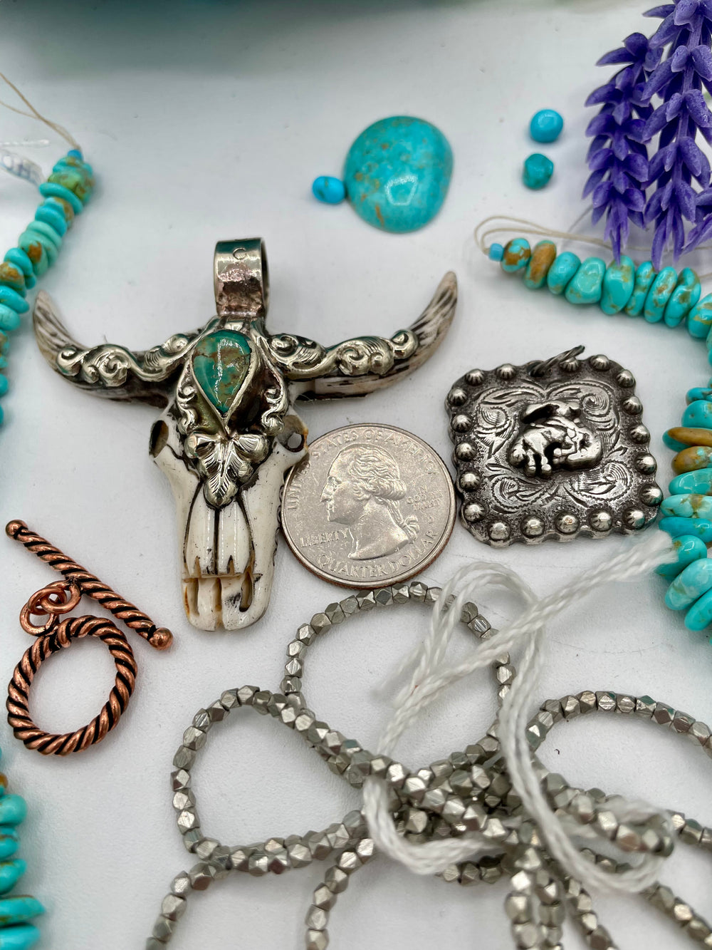 Bead box featuring Campitios and Sonoran turquoise, Australian chrysoprase, spinel, smokey quartz, copper plated lava, with a bone steer pendent. U.S. quarter for size reference. Available only from Rockstar Cowgirl online or in store in Cody, Wyoming.
