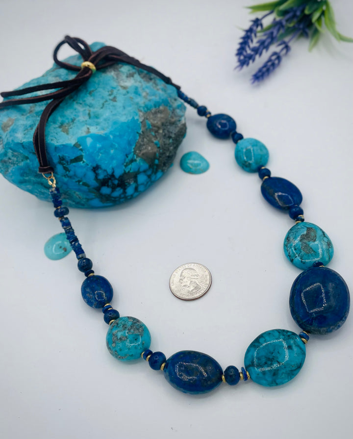 Adjustable beaded hatband featuring lapis nuggets, Kingman turquoise nuggets, African brass details, and finished with deer lace in the back. U.S. quarter for size reference. Available only from Rockstar Cowgirl online or in store in Cody, Wyoming.