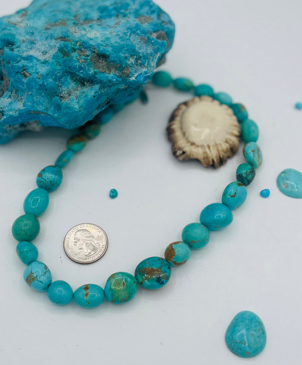 Graduated beaded necklace featuring Kingman turquoise with gold matrix in shades of blue and green. U.S. quarter for size reference. Available only from Rockstar Cowgirl online or in store in Cody, Wyoming.
