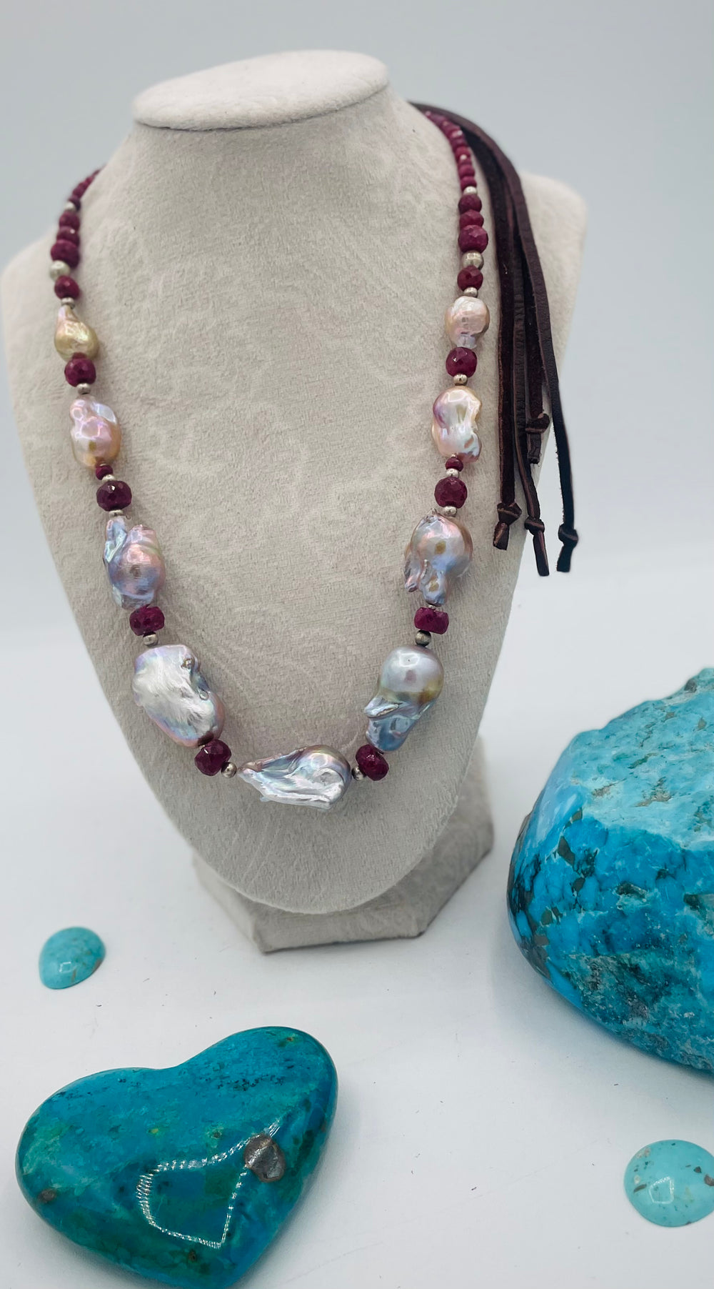 Adjustable beaded hatband featuring flameball natural luster baroque pearls, ruby, sterling silver beads, African silver, and finished with deer lace in the back. Available only from Rockstar Cowgirl online or in store in Cody, Wyoming.