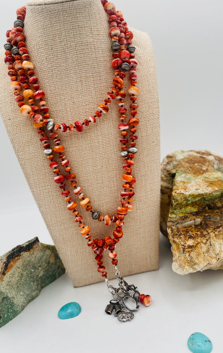 Silk knotted lariat necklace featuring spiney oyster, sterling silver stamped beads, and vintage sterling silver western charms. Available only from Rockstar Cowgirl online or in store in Cody, Wyoming. 