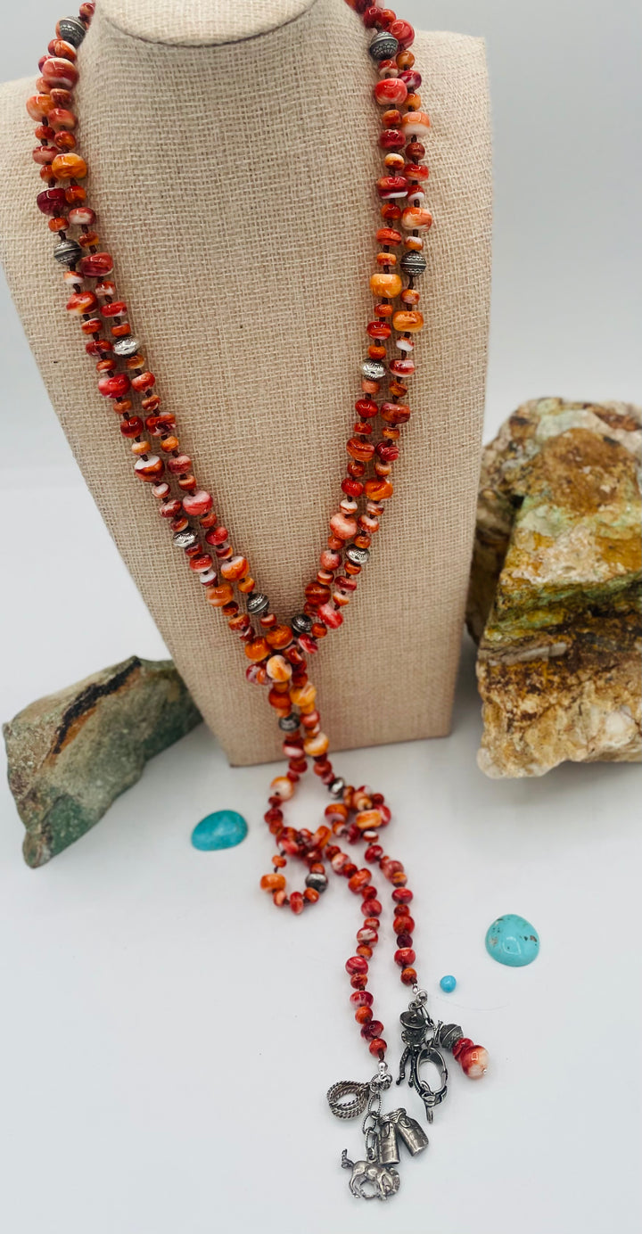 Silk knotted lariat necklace featuring spiney oyster, sterling silver stamped beads, and vintage sterling silver western charms. Available only from Rockstar Cowgirl online or in store in Cody, Wyoming. 