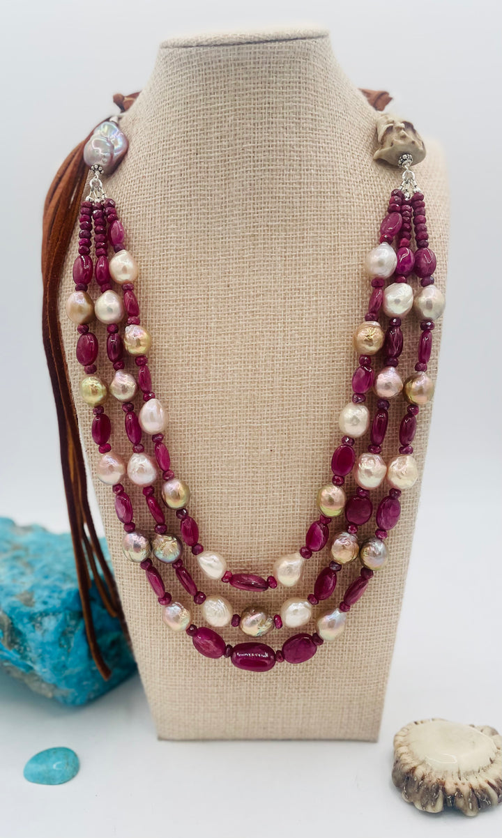 Adjustable 3 strand necklace featuring ruby, Edison pearls, flameball baroque pearl, textured deer antler bead, and finished with deer lace. Available only from Rockstar Cowgirl online or in store in Cody, Wyoming.