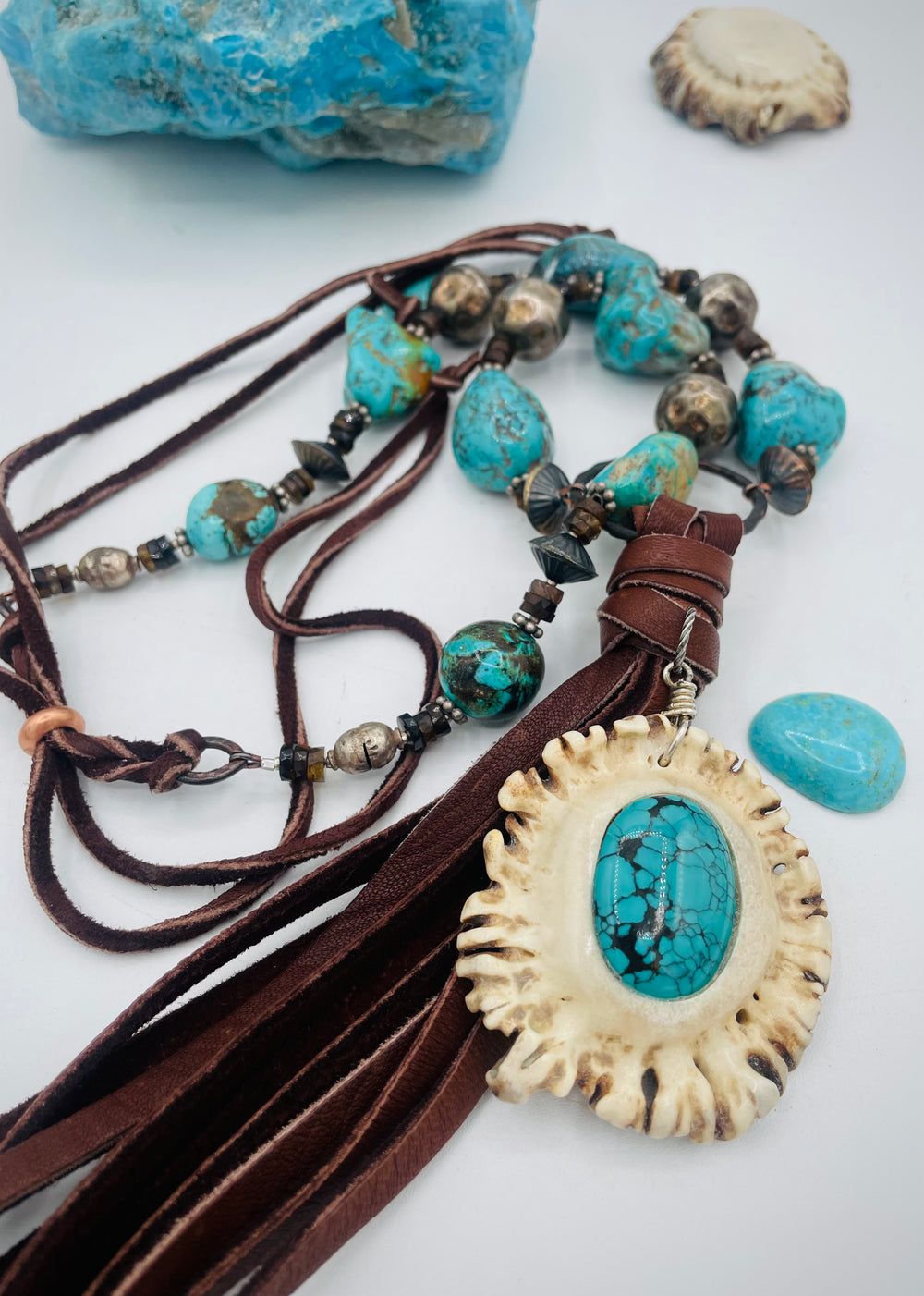 Adjustable beaded necklace featuring Kingman turquoise, hessonite garnet, vintage sterling silver, deer lace tassel with deer antler pendent, and finished with deer lace in the back. Available only from Rockstar Cowgirl online or in store in Cody, Wyoming.