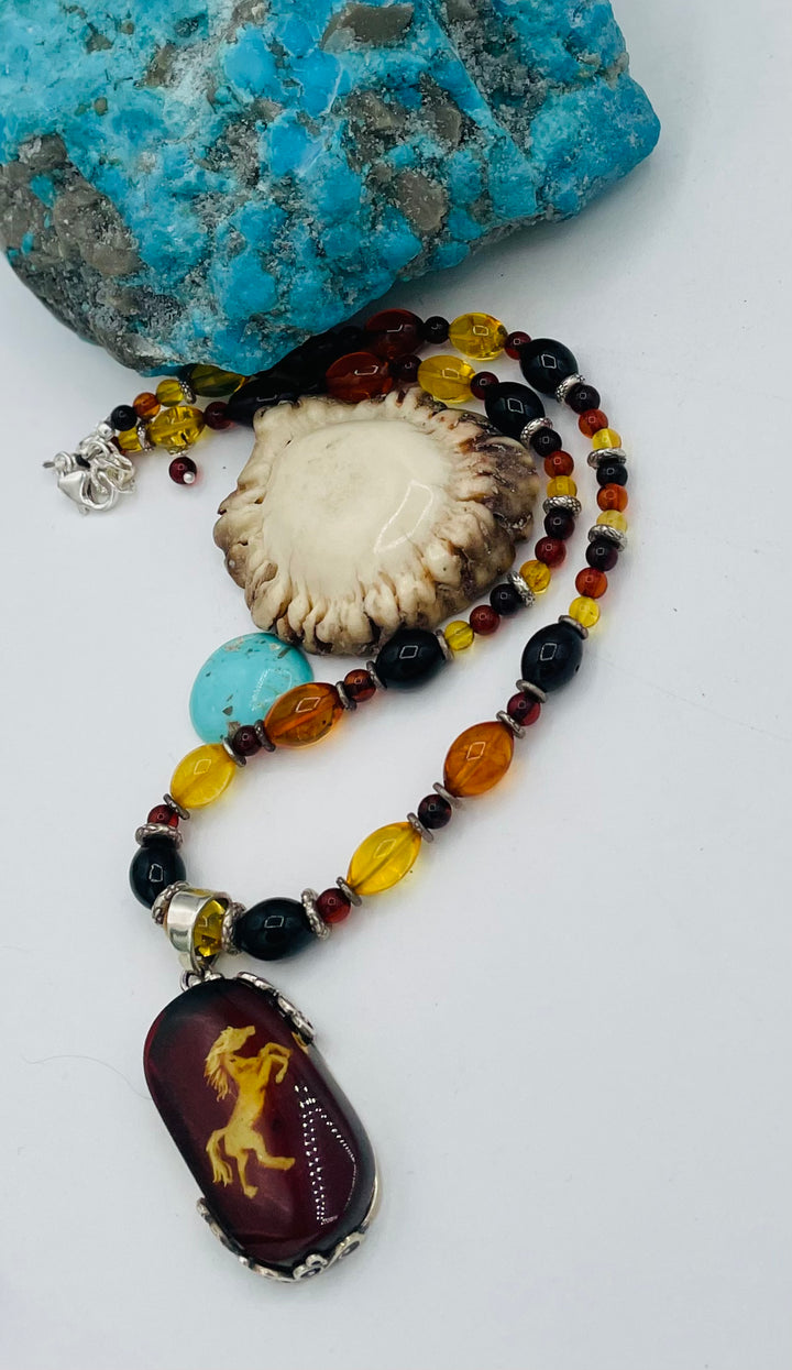 Beaded Baltic amber and sterling silver necklace featuring a Baltic amber and sterling silver pendent with a carved horse reverse cameo. Available only from Rockstar Cowgirl online or in store in Cody, Wyoming.