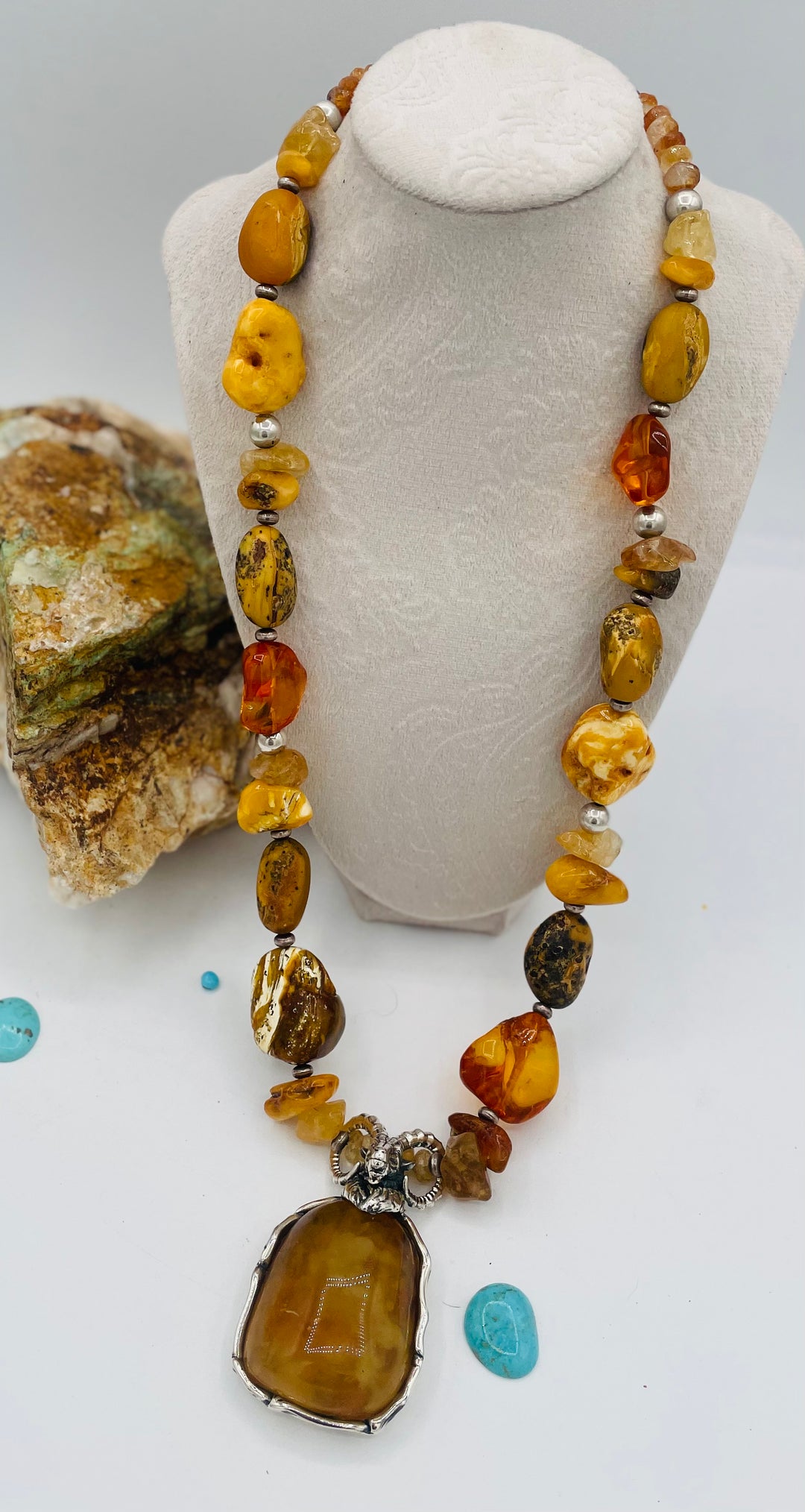 Beaded necklace featuring Baltic amber nuggets and chips, citrine nuggets, sterling silver beads, with a sterling silver and Baltic amber mountain goat pendent. Available only from Rockstar Cowgirl online or in store in Cody, Wyoming. 