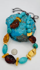 Adjustable beaded hatband featuring Kingman turquoise, Baltic amber, and sterling silver Navajo pearl beads and finished with deer leather and a silicone slide bead. U.S. quarter for size reference. Available only from Rockstar Cowgirl online or in store in Cody, Wyoming.