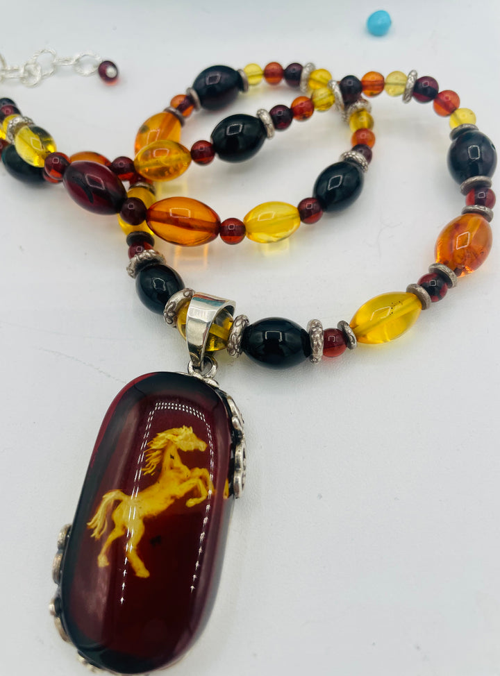 Beaded Baltic amber and sterling silver necklace featuring a Baltic amber and sterling silver pendent with a carved horse reverse cameo. Available only from Rockstar Cowgirl online or in store in Cody, Wyoming.