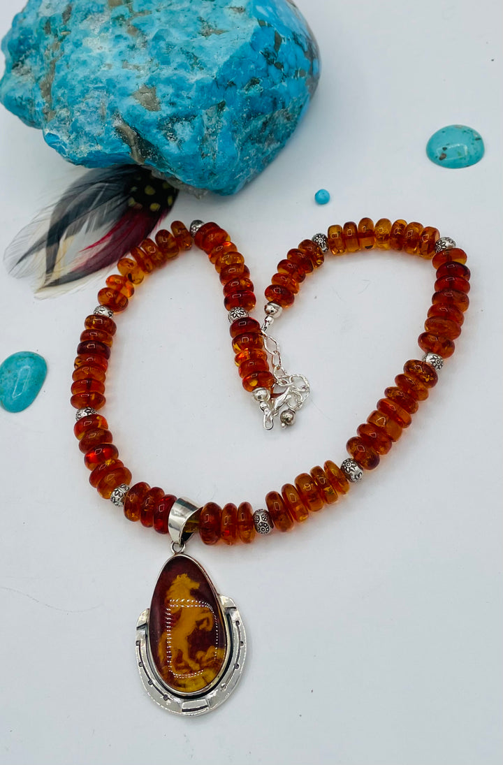 Beaded Baltic amber and sterling silver necklace featuring a Baltic amber and sterling silver pendent with a carved horse reverse cameo. Available only from Rockstar Cowgirl online or in store in Cody, Wyoming.