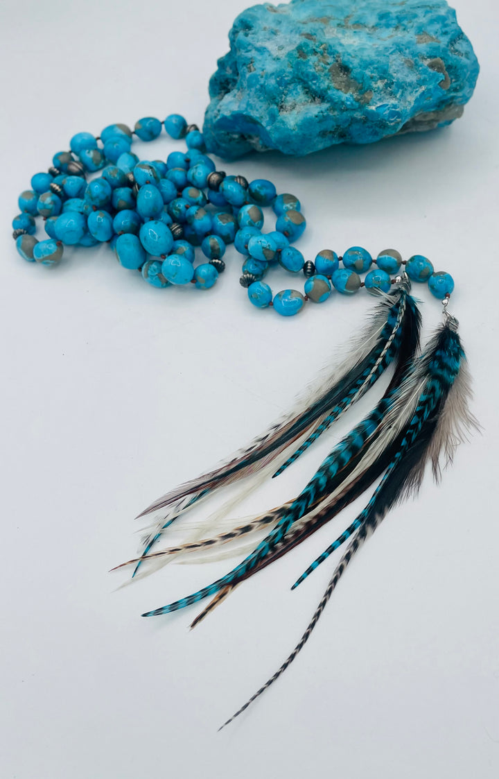Silk knotted lariat featuring Ithaca peak turquoise, sterling silver beads, and feather tassels. Available only from Rockstar Cowgirl online or in store in Cody, Wyoming.
