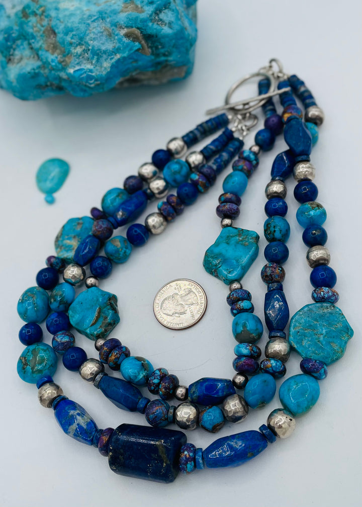 Chunky 3 strand beaded necklace featuring lapis, purple Mojave turquoise, sterling silver beads, Ithaca Peak turquoise, and Kingman turquoise. U.S. quarter for size reference. Available only from Rockstar Cowgirl online or in store in Cody, Wyoming.