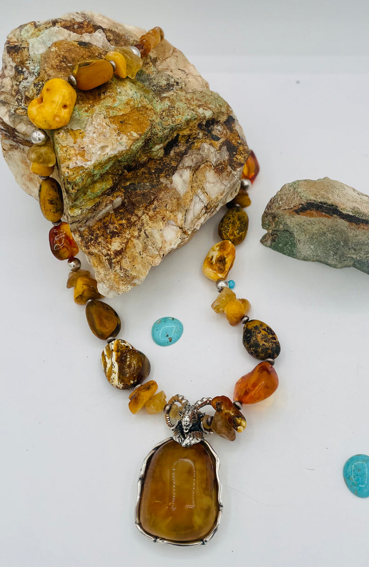 Beaded necklace featuring Baltic amber nuggets and chips, citrine nuggets, sterling silver beads, with a sterling silver and Baltic amber mountain goat pendent. Available only from Rockstar Cowgirl online or in store in Cody, Wyoming. 
