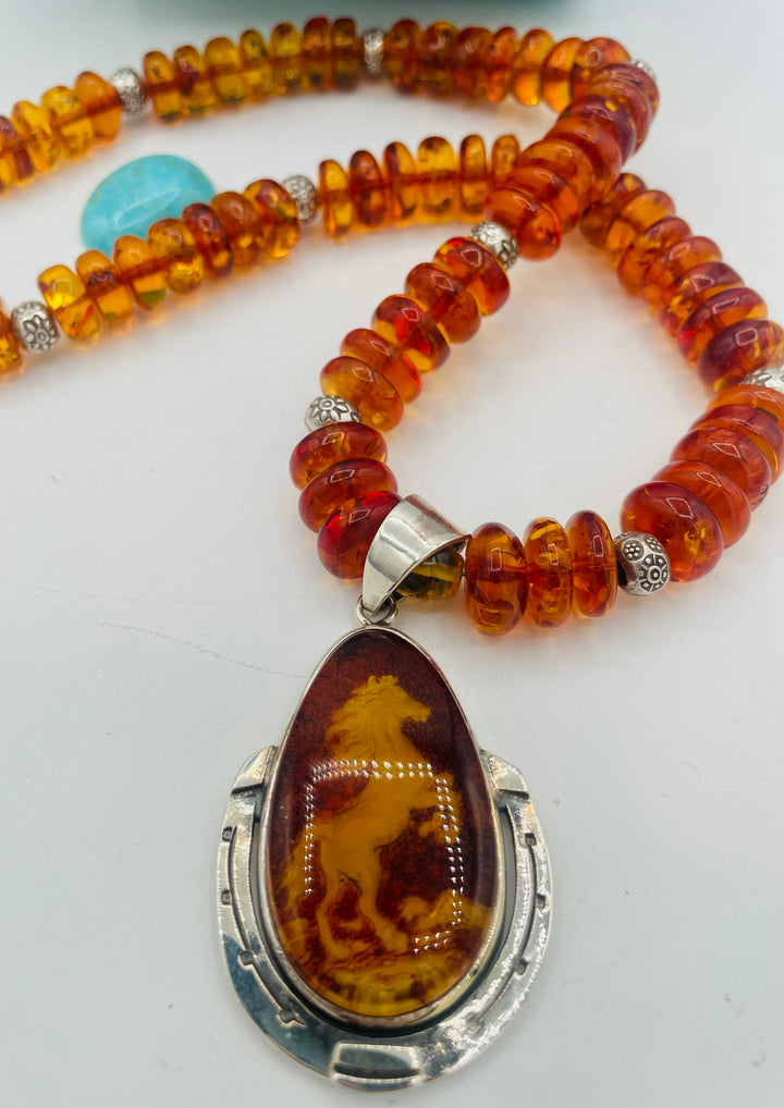 Beaded Baltic amber and sterling silver necklace featuring a Baltic amber and sterling silver pendent with a carved horse reverse cameo. Available only from Rockstar Cowgirl online or in store in Cody, Wyoming.
