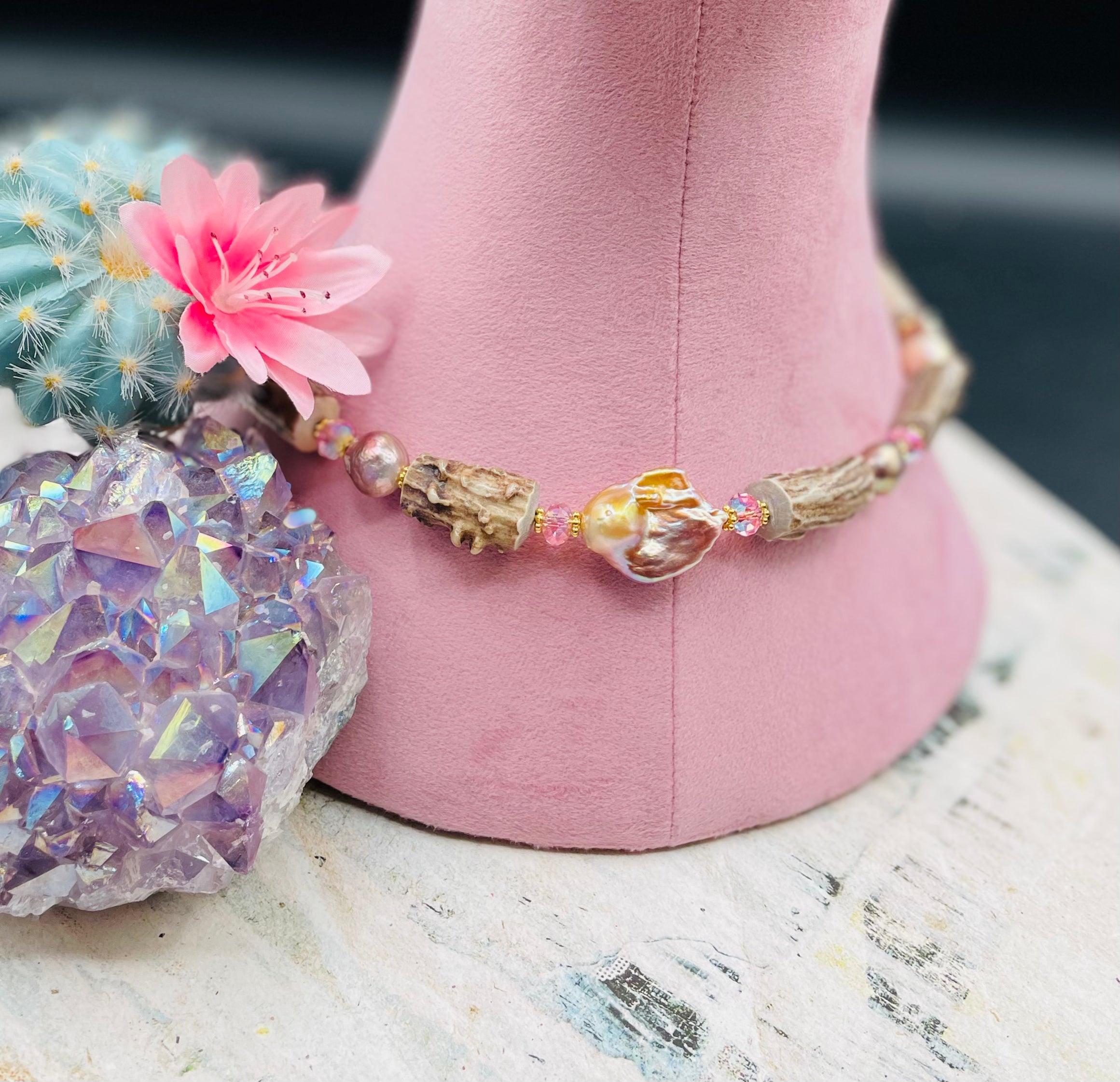 Close up of the front of the hatband showcasing the largest natural luster baroque pearl, vintage pink Swarovski, and the knobby deer antlers. Available only from Rockstar Cowgirl online or in store in Cody, Wyoming. 