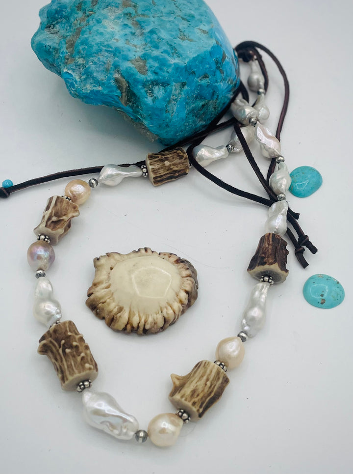Adjustable beaded hattband featuring white flameball baroque pearls, textured deer antler, sterling silver beads, and finished with deer lace in the back. Available only from Rockstar Cowgirl online or in store in Cody, Wyoming.