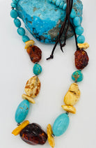 Adjustable beaded hatband featuring Kingman turquoise, Baltic amber, and sterling silver Navajo pearl beads and finished with deer leather and a silicone slide bead. Available only from Rockstar Cowgirl online or in store in Cody, Wyoming.
